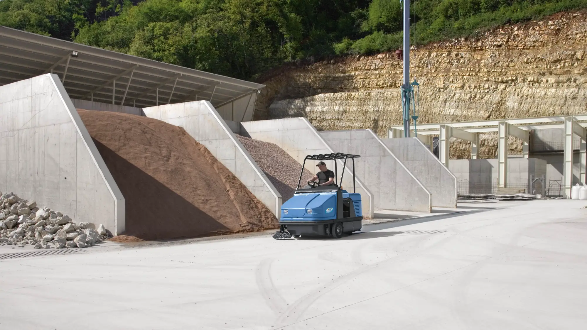 Fimap FS ride-on sweeper working beside aggregate stockpiles at a quarry