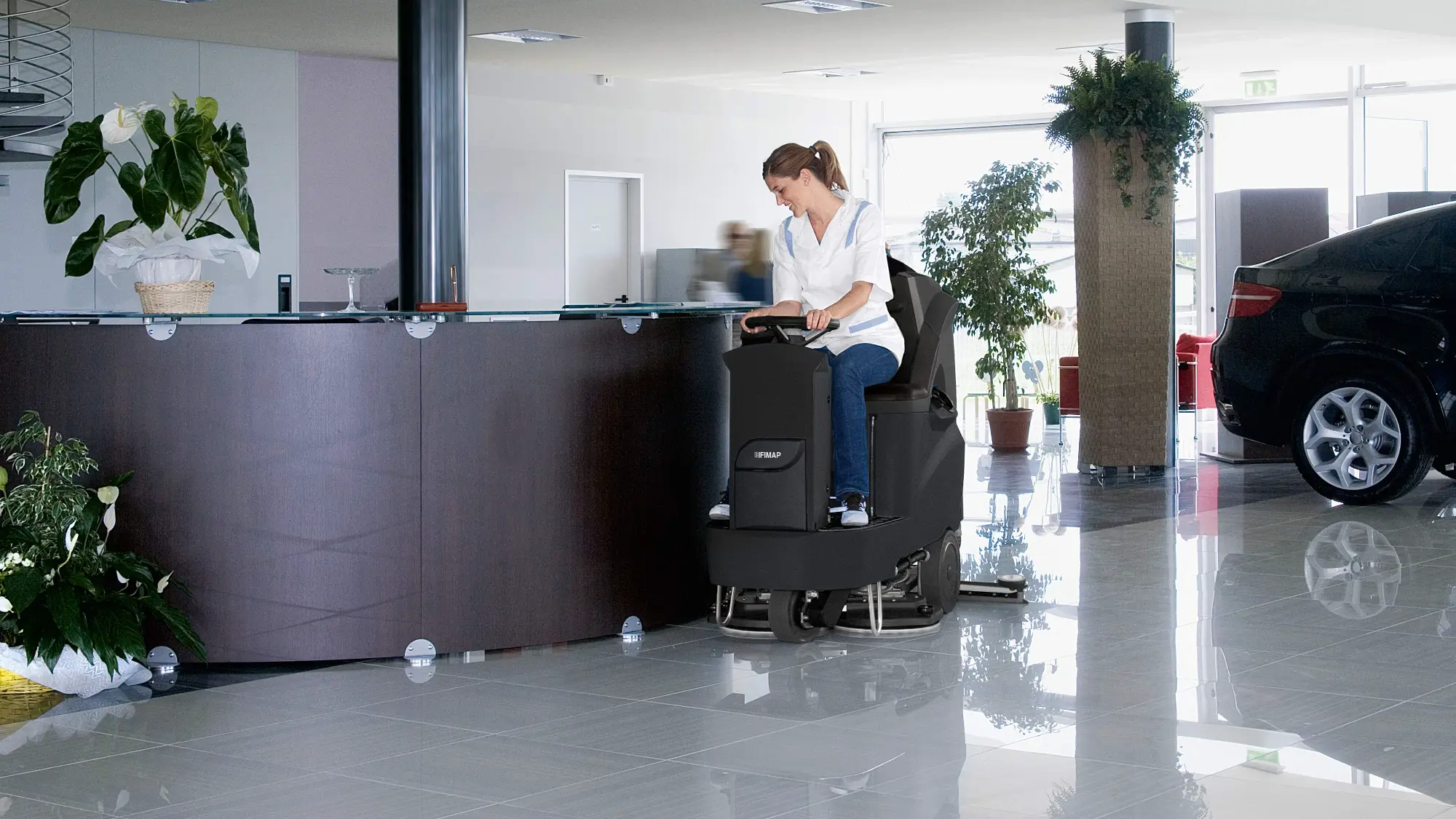 Fimap ride-on scrubber cleaning a tiled showroom floor